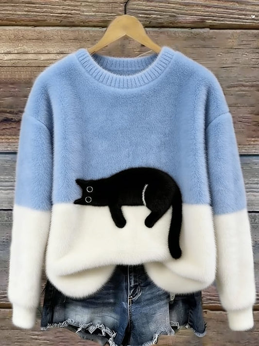 Pale blue and white fluffy jumper with black cat motif, hanging on a wooden background 2