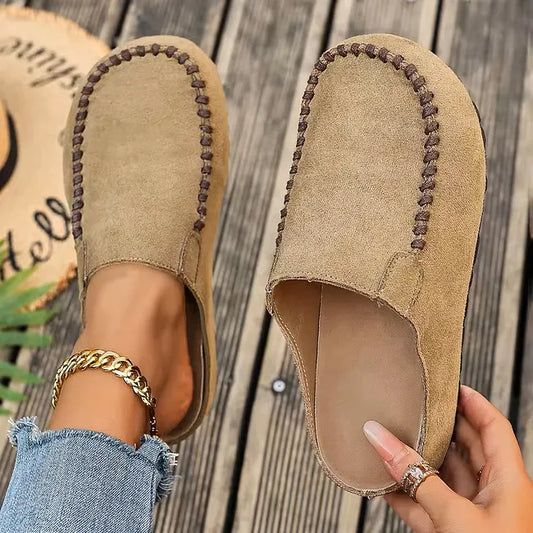 Light khaki version seen from above, one clog worn with a gold ankle chain and the other held to reveal the pale insole. 2