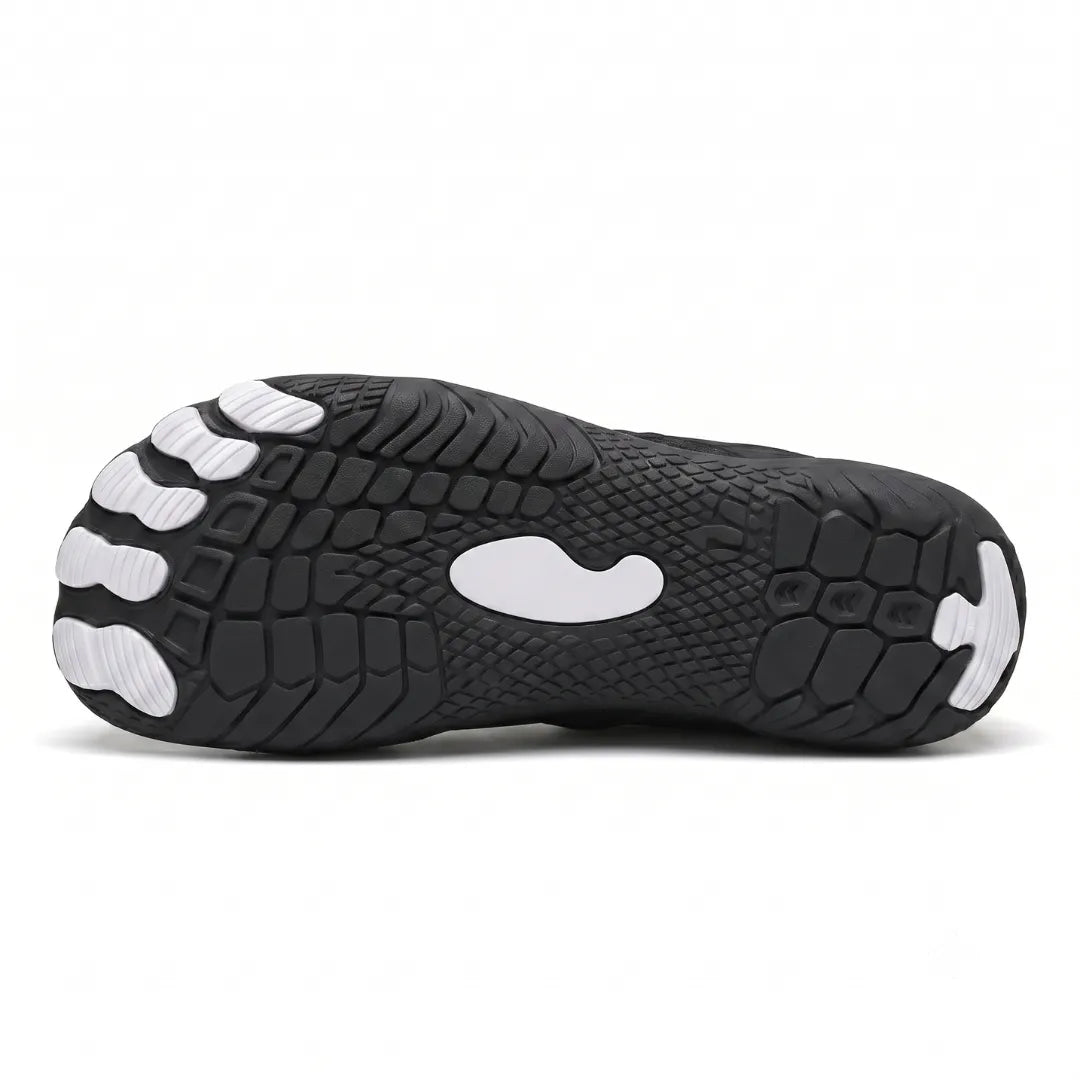 Underside of the black trainer showing the textured tread pattern with white toe pads, a white central patch and a white heel tip. 45