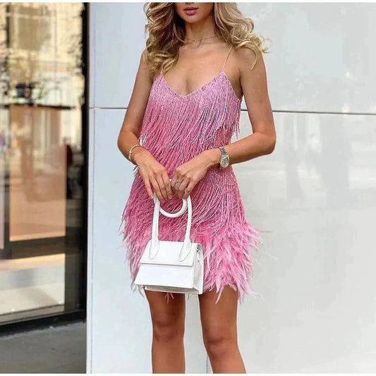 Close crop of the pink fringed dress on a model holding a small white handbag 2