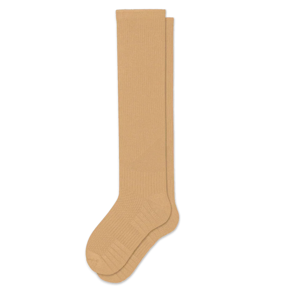 Pair of tan knee-high ribbed socks laid flat on a white background, showing the textured heel and toe. 5