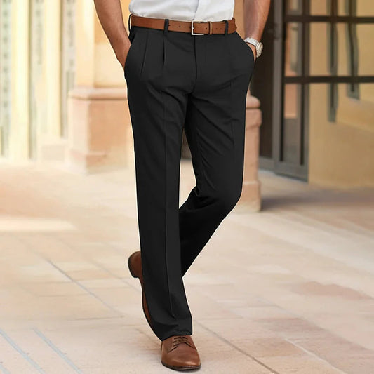 The same pleated trousers in black, worn by a model with a brown belt, white shirt and tan shoes. 2