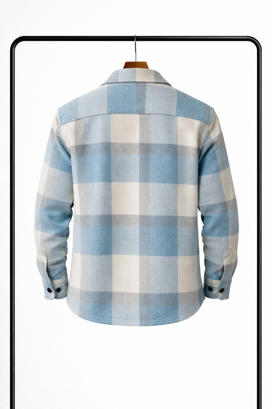 Back view of the pale blue, cream and grey check overshirt on a wooden hanger, showing the yoke and buttoned cuffs. 2