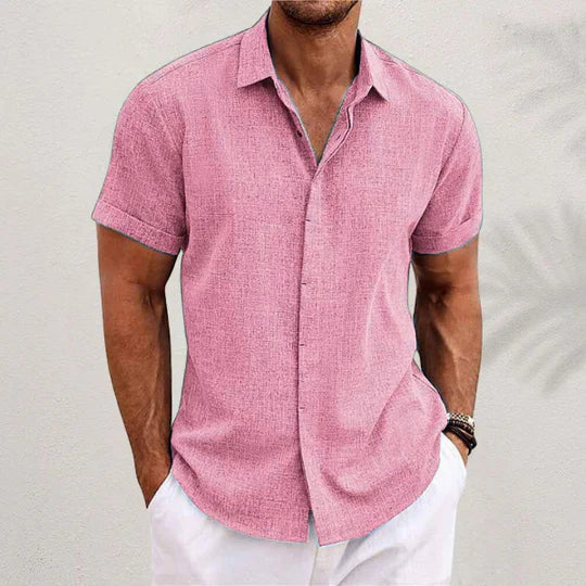 Pink textured short-sleeve shirt with cuffed sleeves and a spread collar, worn by a model with white trousers. 8