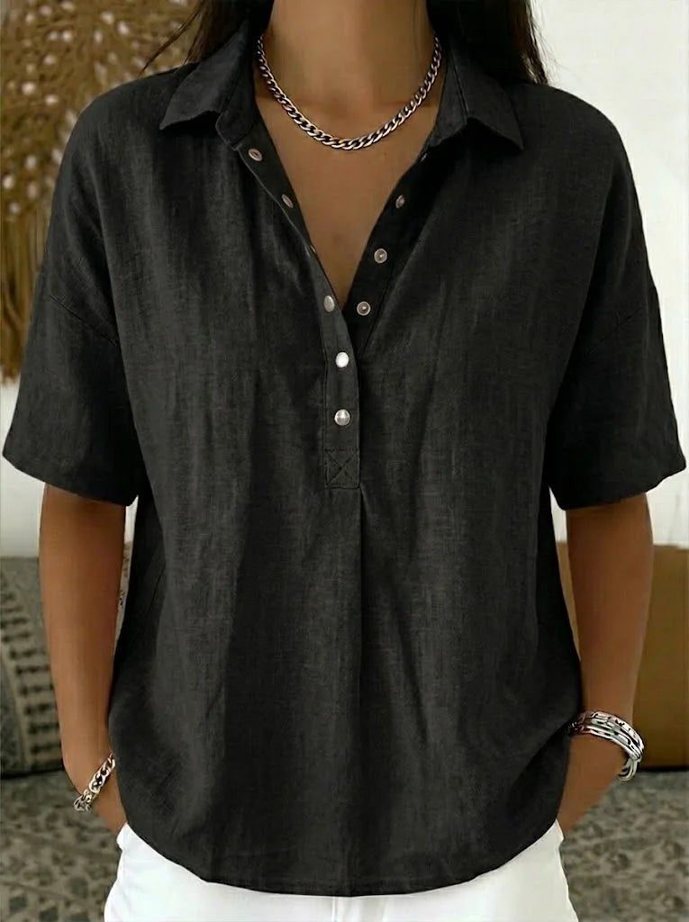 Short-sleeved blouse in black, worn by a model with a chain necklace and white trousers 6