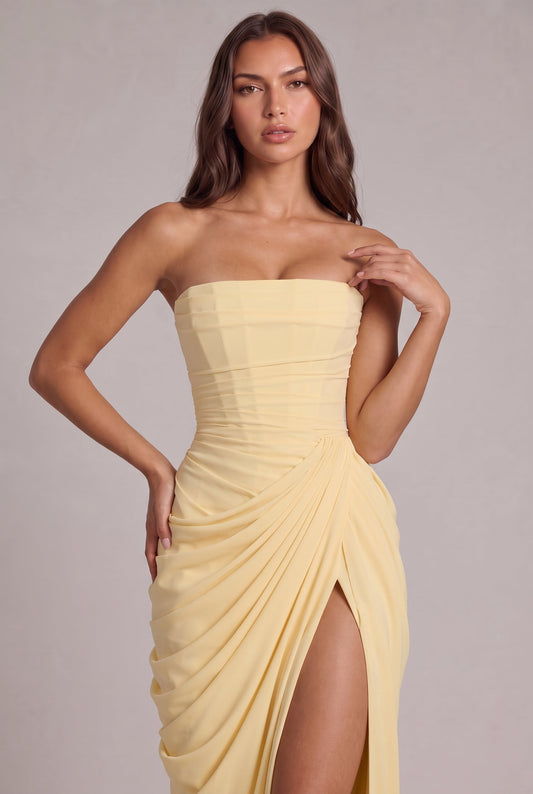 Close-up of the pale yellow corset bodice and ruched waist, model's hand resting on hip 2