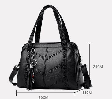 Black handbag with dimension lines marking its width, height and depth, showing braided handles, tassel and charm. 8