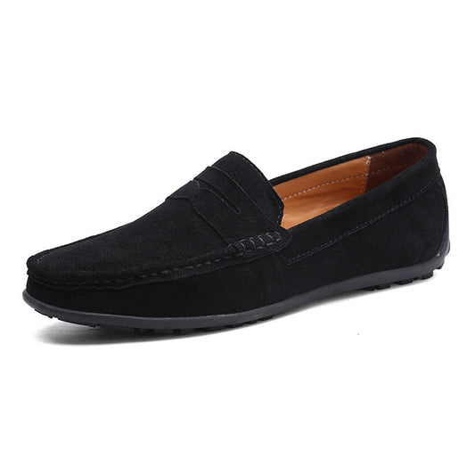 Black suede penny loafer seen from the front three-quarter angle, with tan leather lining and a flexible black rubber sole. 1
