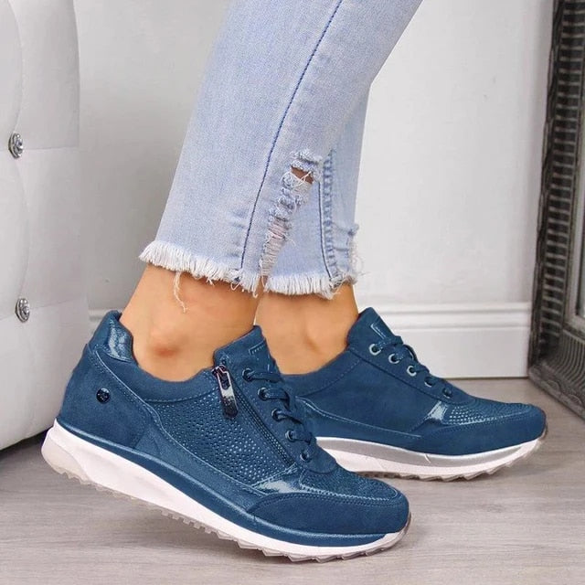 Blue version of the lace-up trainers with side zip and white cushioned sole, worn with frayed light-blue jeans. 5