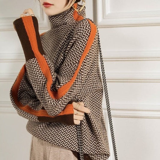 Close-up of a model in the orange-striped herringbone knit, arms crossed, with a chain bag strap 2