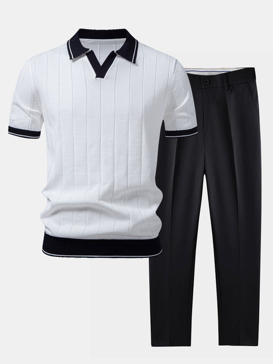 Flat lay of a white ribbed knit polo with navy collar and cuff trim, paired with black tapered trousers. 1