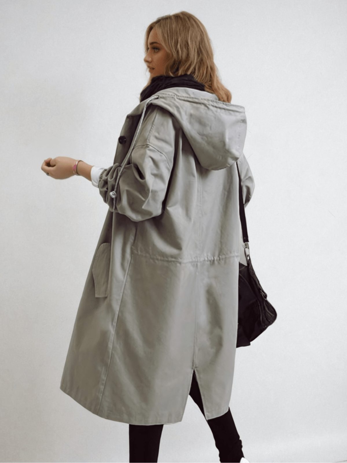 Rear three-quarter view of the grey hooded coat, showing the back vent and drawstring waist 8