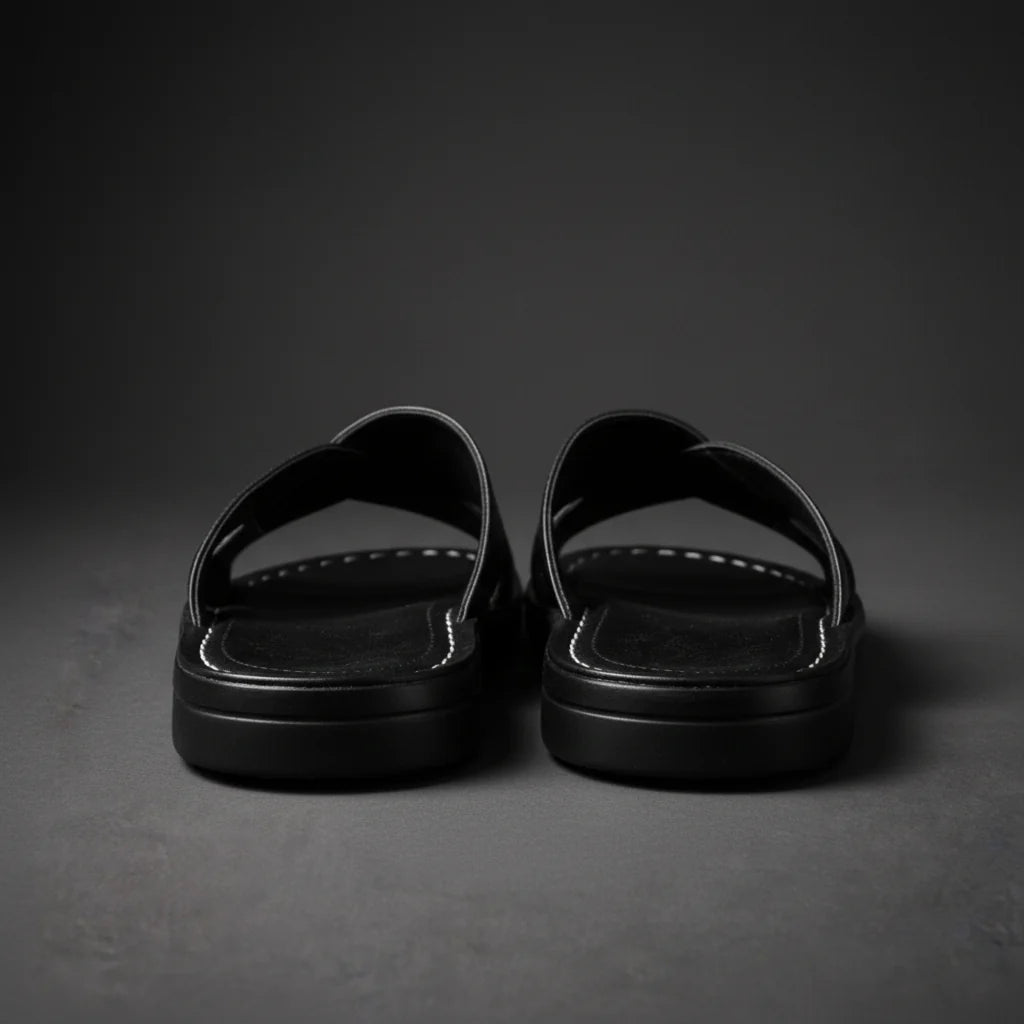 Rear view of a pair of black sandals showing the thick layered soles, open heels and white-stitched footbeds. 9