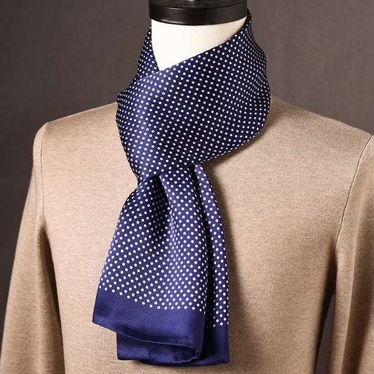 Navy silk scarf with small white polka dots and plain navy ends, draped on a mannequin over a beige jumper. 2