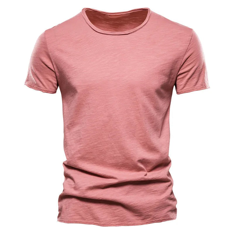 Front view of the short-sleeved crew-neck t-shirt in dusty coral pink, showing the textured slub fabric and raw-edged hems. 11
