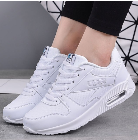 Worn view of all-white trainers with an air cushion heel and white laces 9