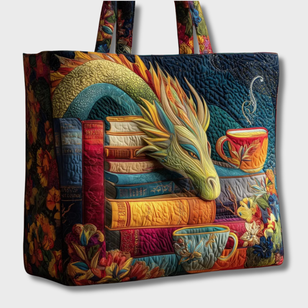 Same quilted tote with dragon, books and teacups cut out against a plain pale background, showing the floral side panel and handles. 2
