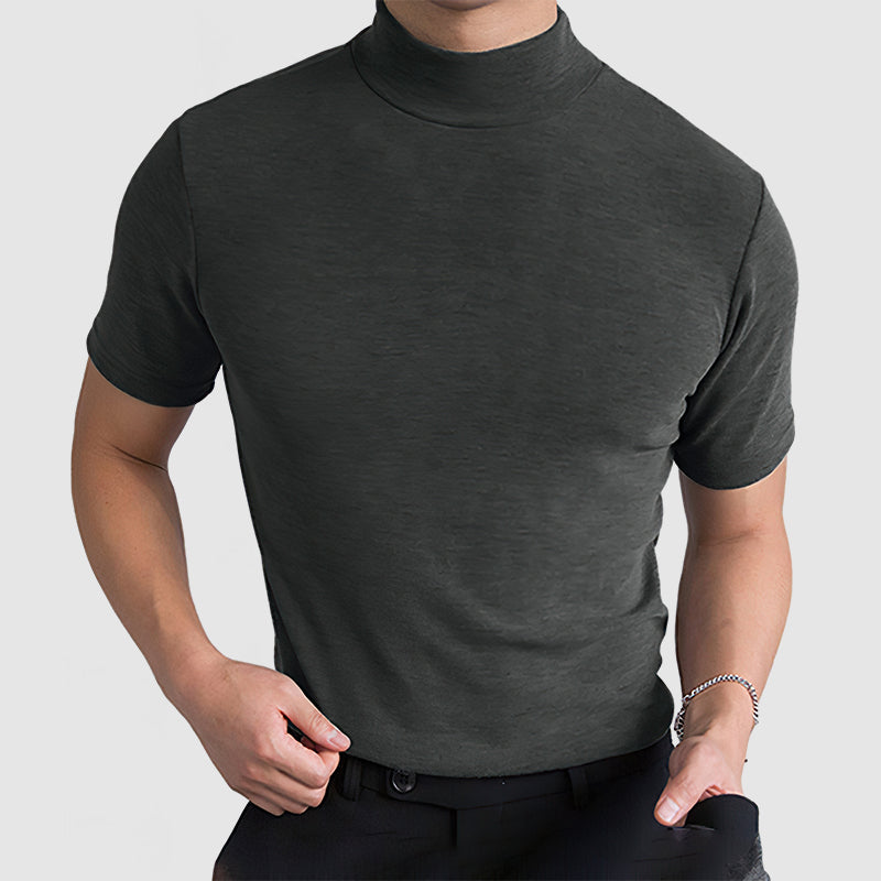 Dark grey mock-neck tee on a model with one hand at the belt and a bracelet on the wrist. 9