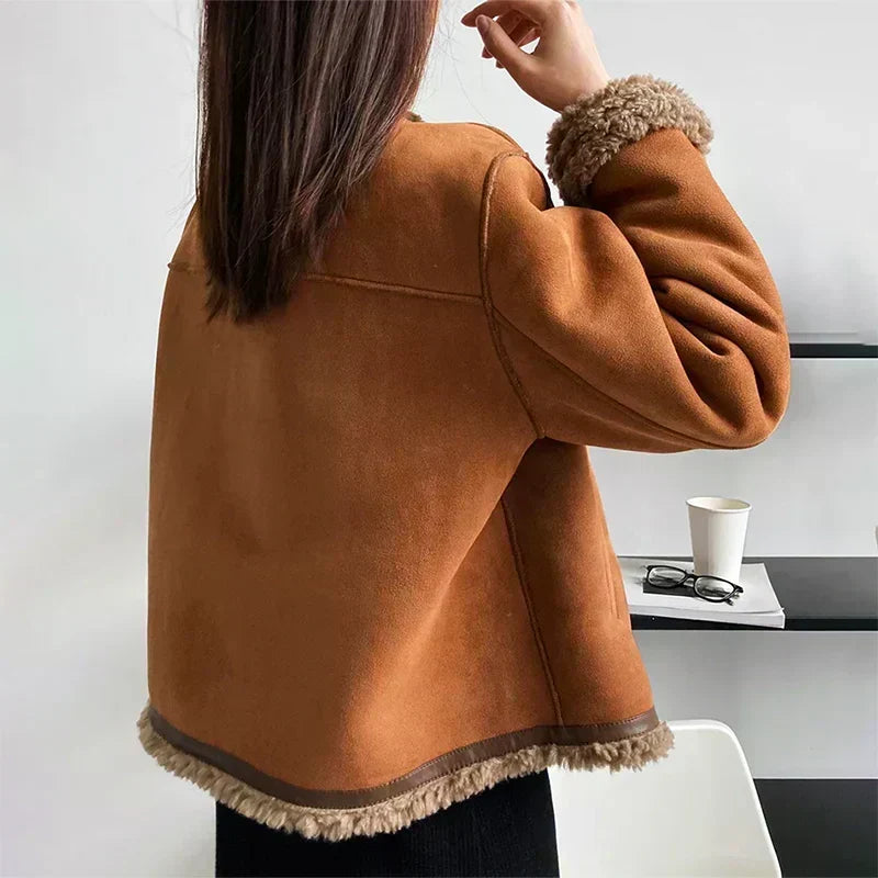 Back view of the tan suede jacket showing seam details and fleecy trim at the hem and cuff 3