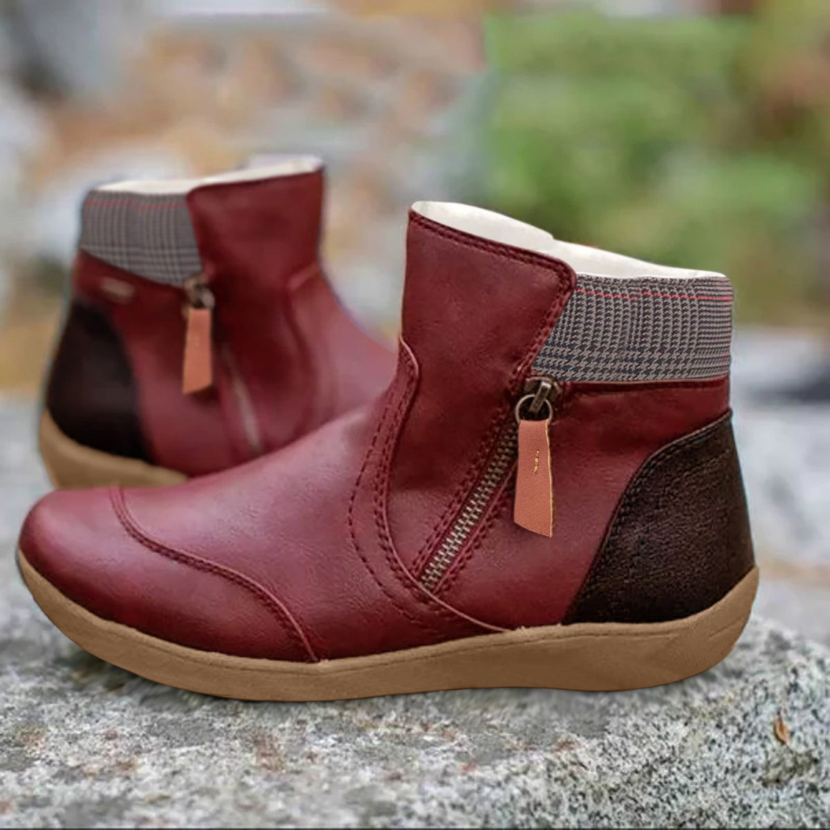 Burgundy red version of the ankle boots with side zip, houndstooth collar, dark brown heel panel and tan sole, on a stone. 5