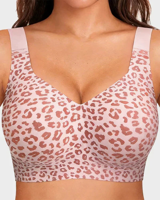 Close-up front view of the wireless bra in a pink leopard print with wide straps and a deep V neckline, worn by a model. 1