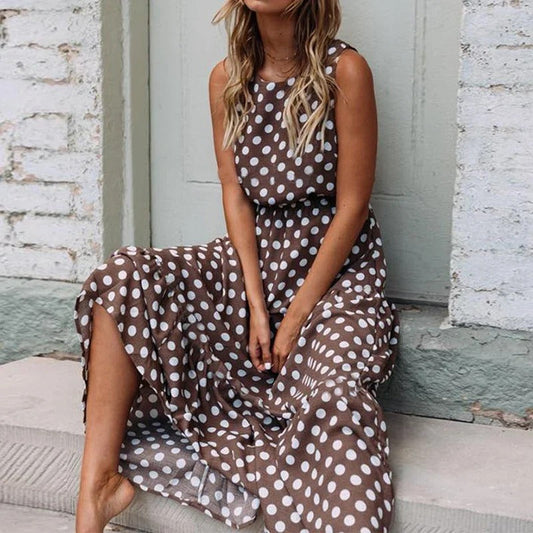 Woman seated on stone steps wearing the brown polka dot dress, skirt flowing over her knees 2