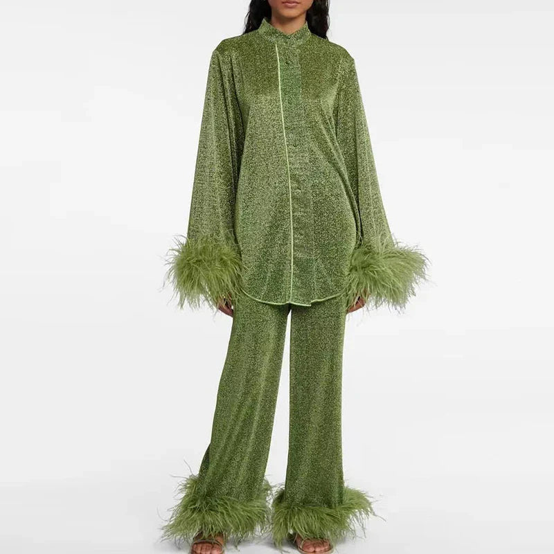Model facing the camera in the olive-green glitter set with contrast piping, feather-trimmed cuffs and flared trousers with feathered hems. 4