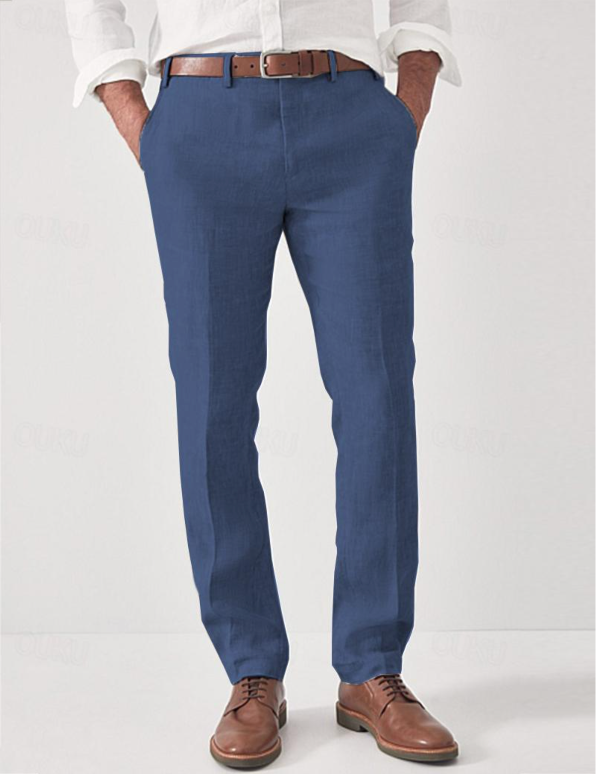 Same linen trousers in mid blue on a model, with brown leather belt, white shirt and brown lace-up shoes. 4