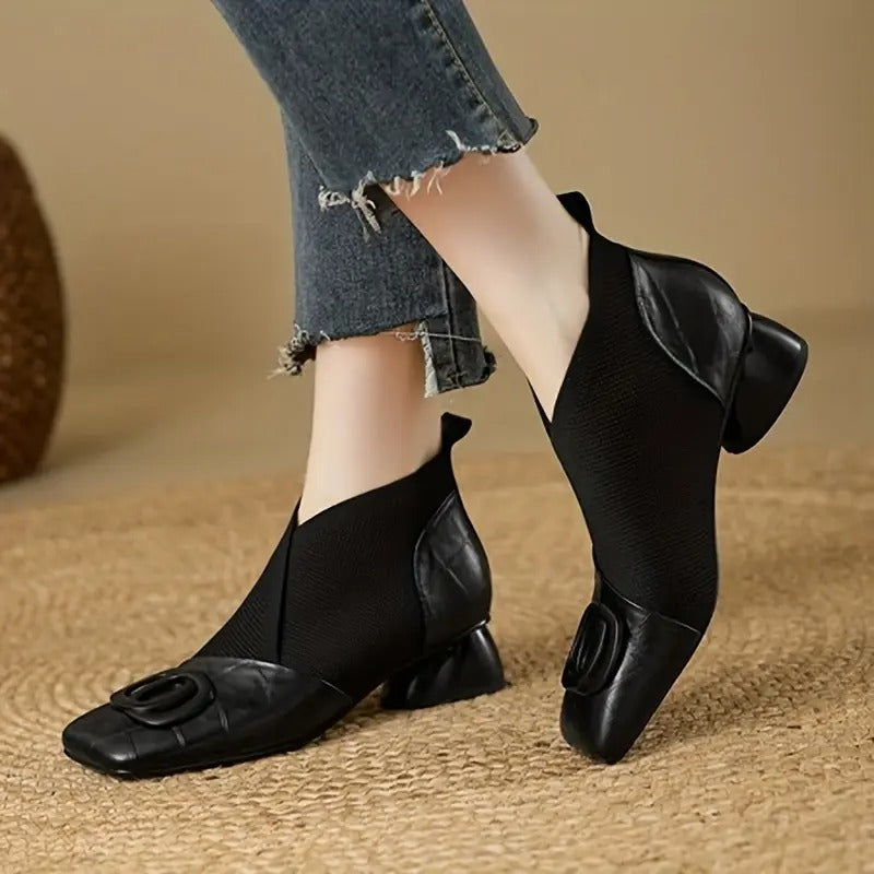 Pair of black knit-and-leather ankle boots with square toes and chunky heels, worn with frayed-hem jeans 2