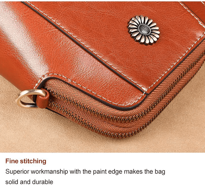Close-up of the tan bag's corner showing the daisy stud, painted edge, stitching and zip 16