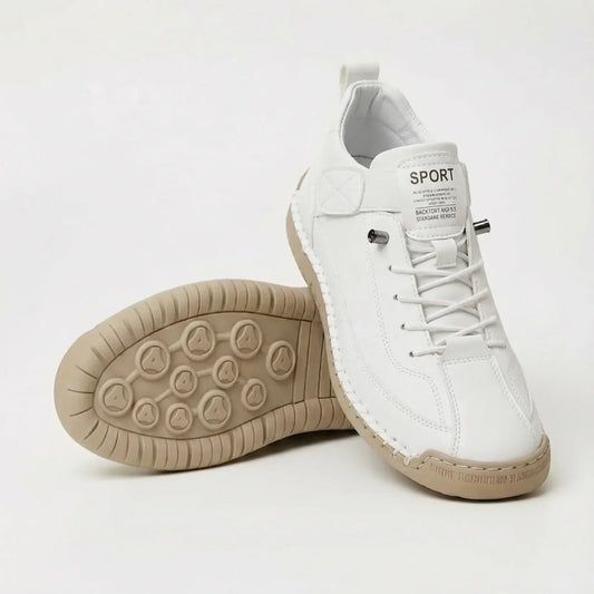 White lace-up trainers with tan sole, one upright and one tilted to show the tread pattern 2