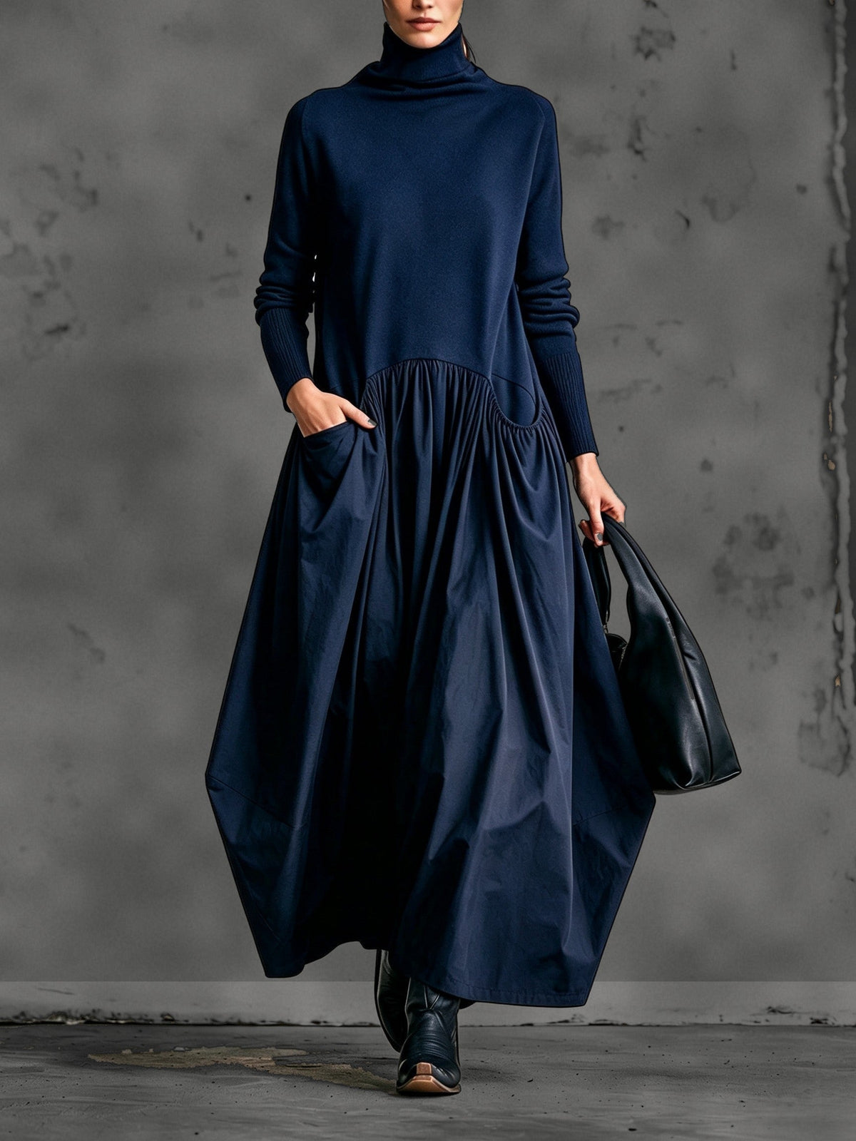 Front view of the dress in deep navy blue, with a hand in the pocket and black boots 6
