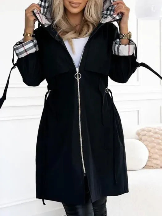 Model wearing the black version of the hooded jacket, zipped up with a ring pull, hood raised and checked lining visible. 4
