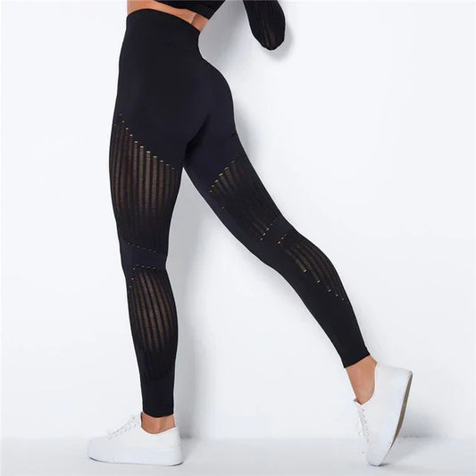 Rear view of black high-waisted leggings with sheer striped panels on the thighs and calves 2