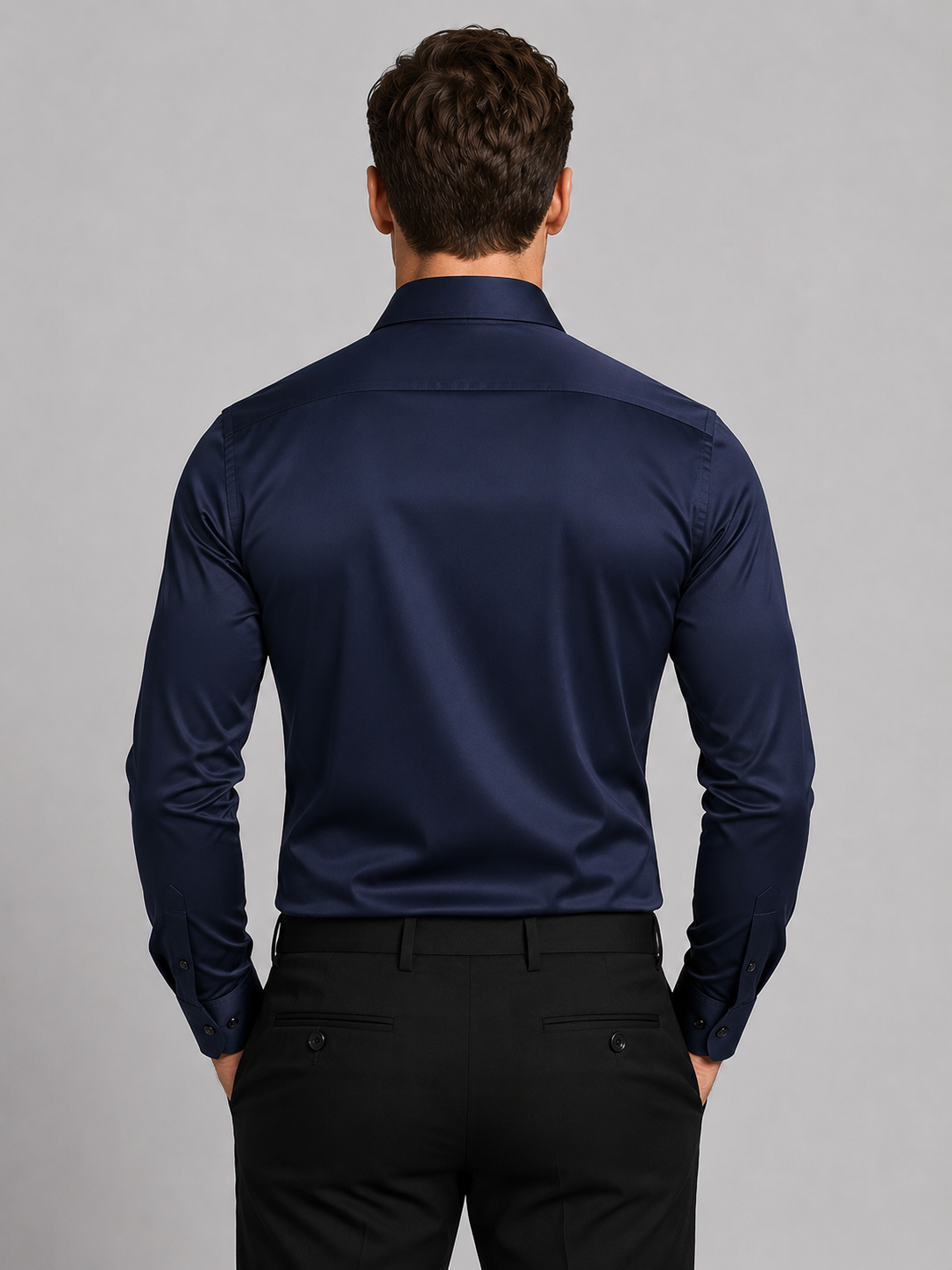 Back view of the navy shirt on a model, showing the yoke and buttoned cuffs 6