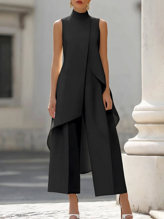 Black version worn by a model, front view, showing the sleeveless high-neck top with its sloping overlap above the wide-leg trousers. 2