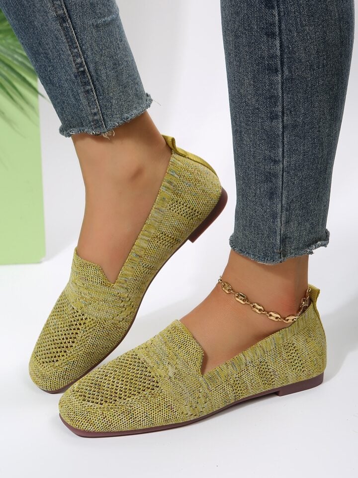 Olive-green knit mesh slip-ons worn with frayed jeans and a gold chain anklet, shown from the side. 18