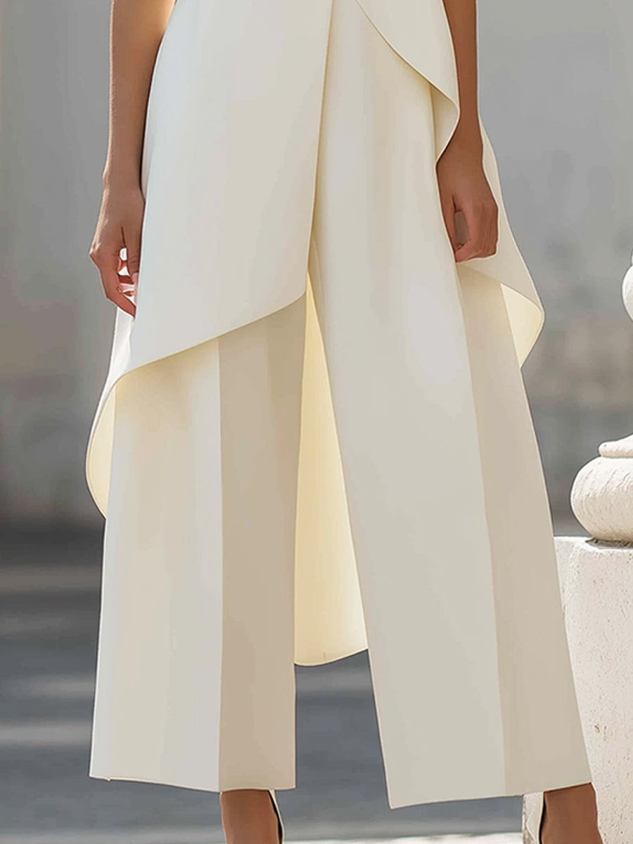 Close-up of the cream wide-leg trousers with the top's curved hem draping over them, showing the pressed front creases. 12