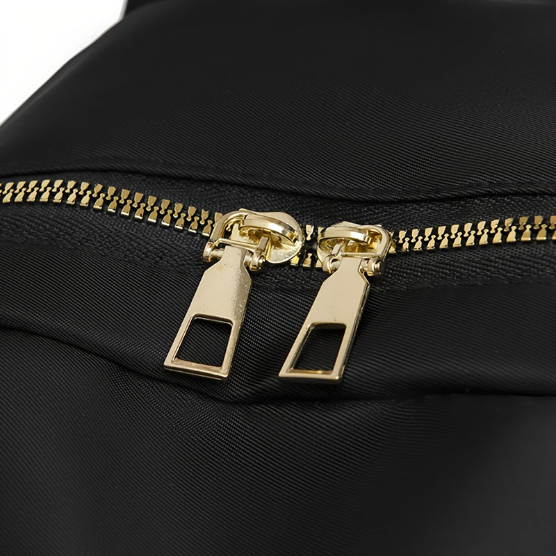 Close-up of two gold zip pulls and chunky gold teeth on the black fabric 9