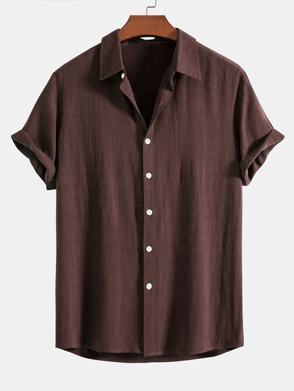 Dark chocolate brown short-sleeved shirt on a wooden hanger, front view with white buttons and cuffed sleeves. 8