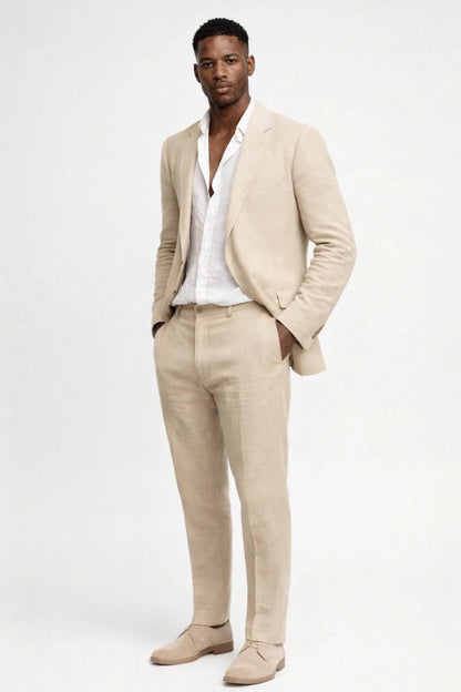 Full-length view of a model in the beige suit with white shirt and suede lace-up shoes, hands in pockets. 3
