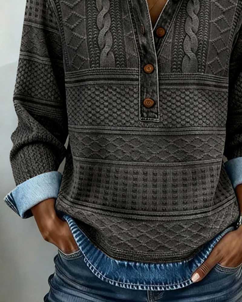 Close-up of the grey sweatshirt's body and turned-back cuff, showing patterned textured bands and the denim-effect hem over jeans. 7