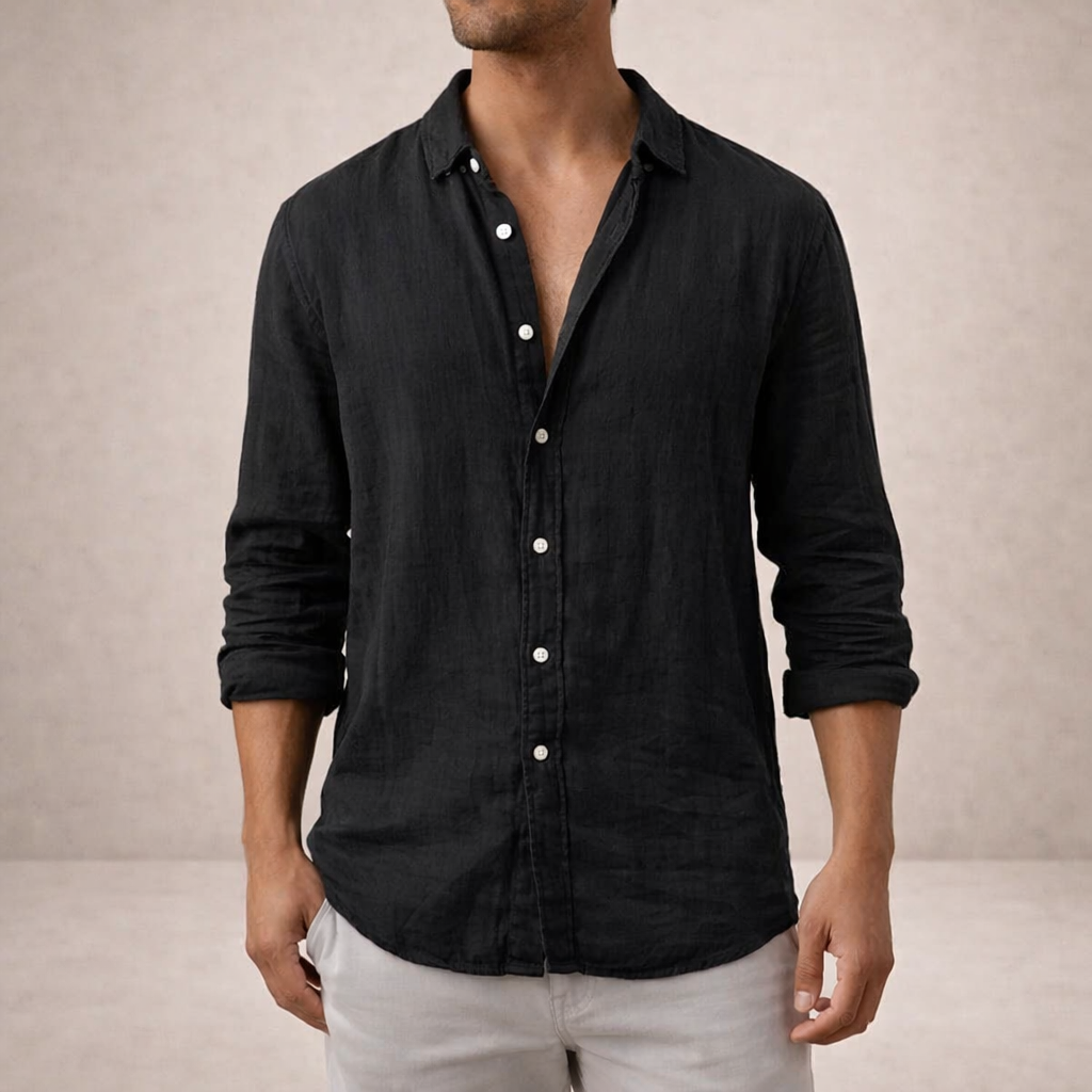 Black linen shirt worn by a model with white buttons, a pointed collar and sleeves rolled to the forearm. 5