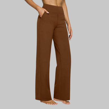 Side view of the high-waist straight-leg trousers in rich chestnut brown, worn by a barefoot model with a hand in the pocket. 13