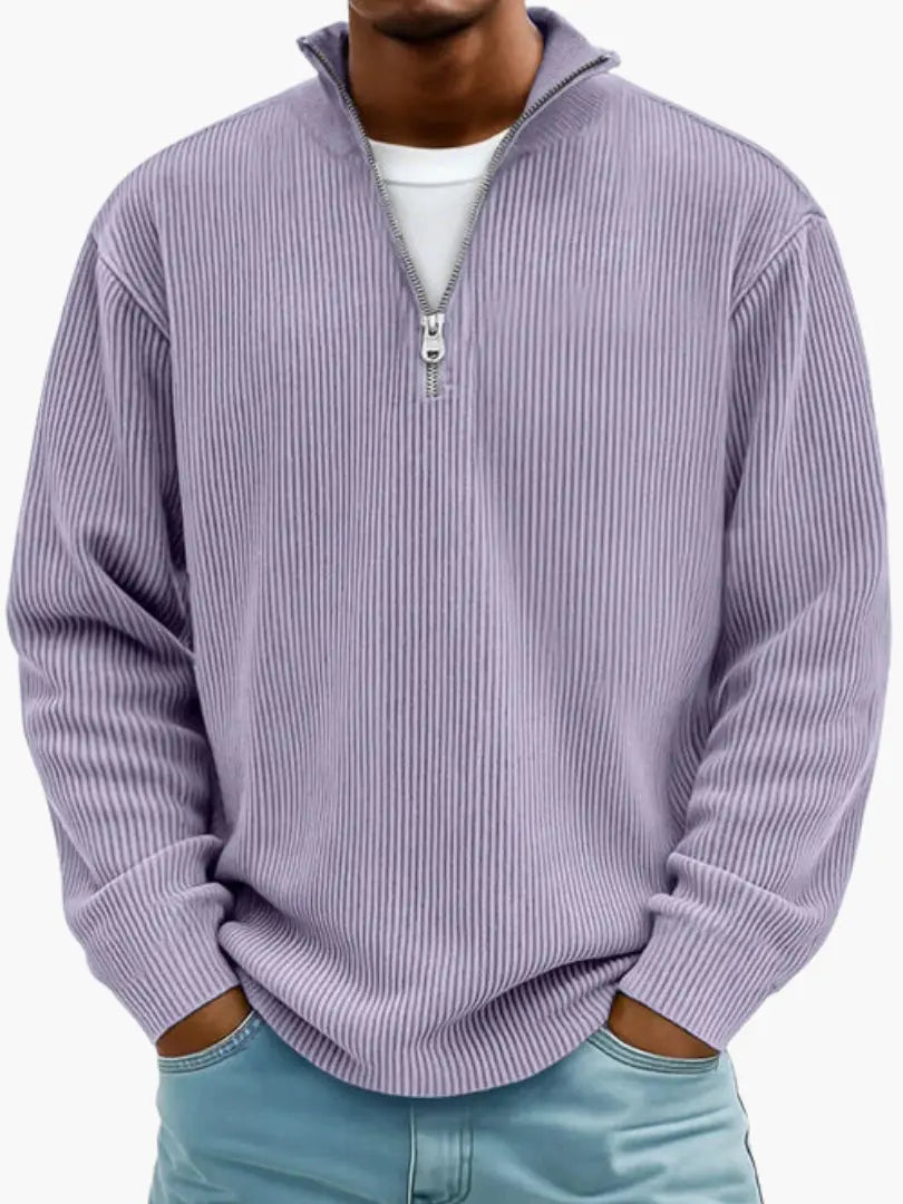 Man wearing the ribbed quarter-zip jumper in lilac purple over a white tee, hands tucked into the pockets of blue jeans. 9