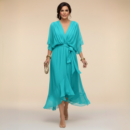 Model in the turquoise chiffon midi dress with plunging V-neck, loose batwing sleeves, tied waist and layered ruffled skirt. 5