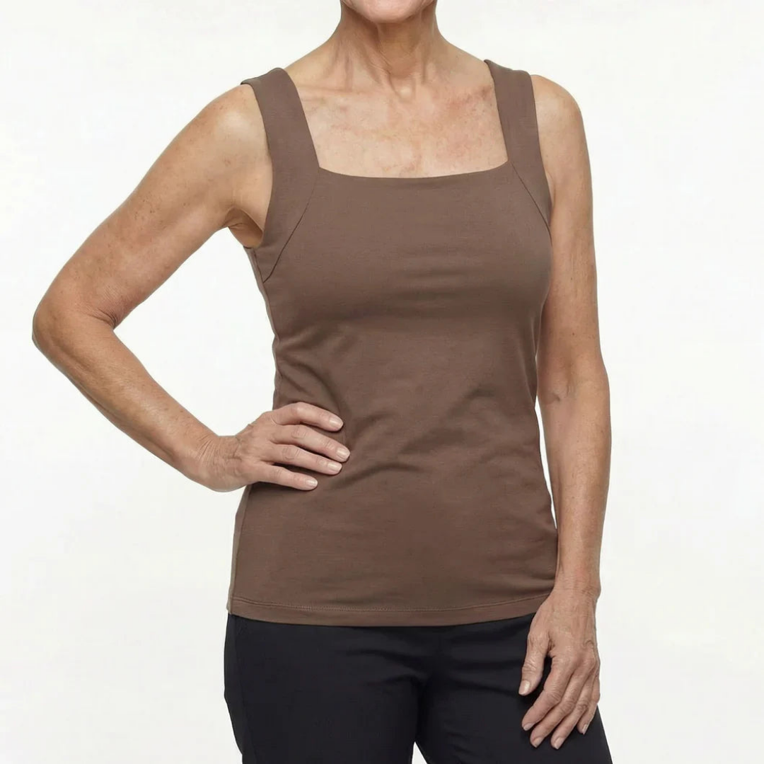 Front view of a woman wearing a fitted brown sleeveless top with a square neckline and wide straps, with black trousers. 3