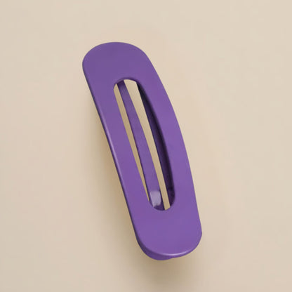 Matte violet flat clip with an elongated oval opening, shown from above on a beige backdrop 11