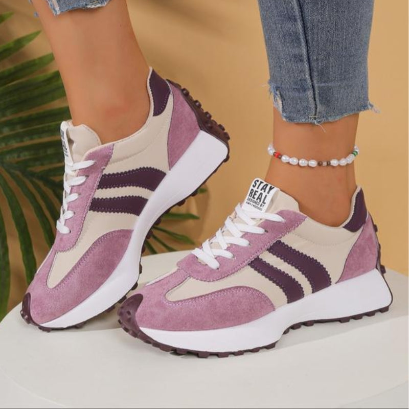 Side view of lilac and beige platform trainers with purple stripes, worn with a pearl anklet 12