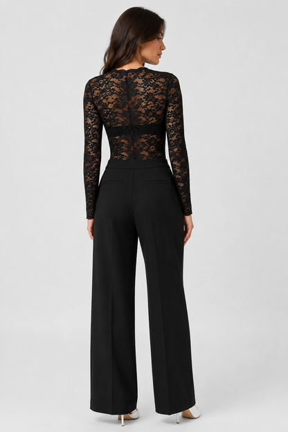 Back view of the sheer black lace bodysuit, worn with black trousers and white heels 4